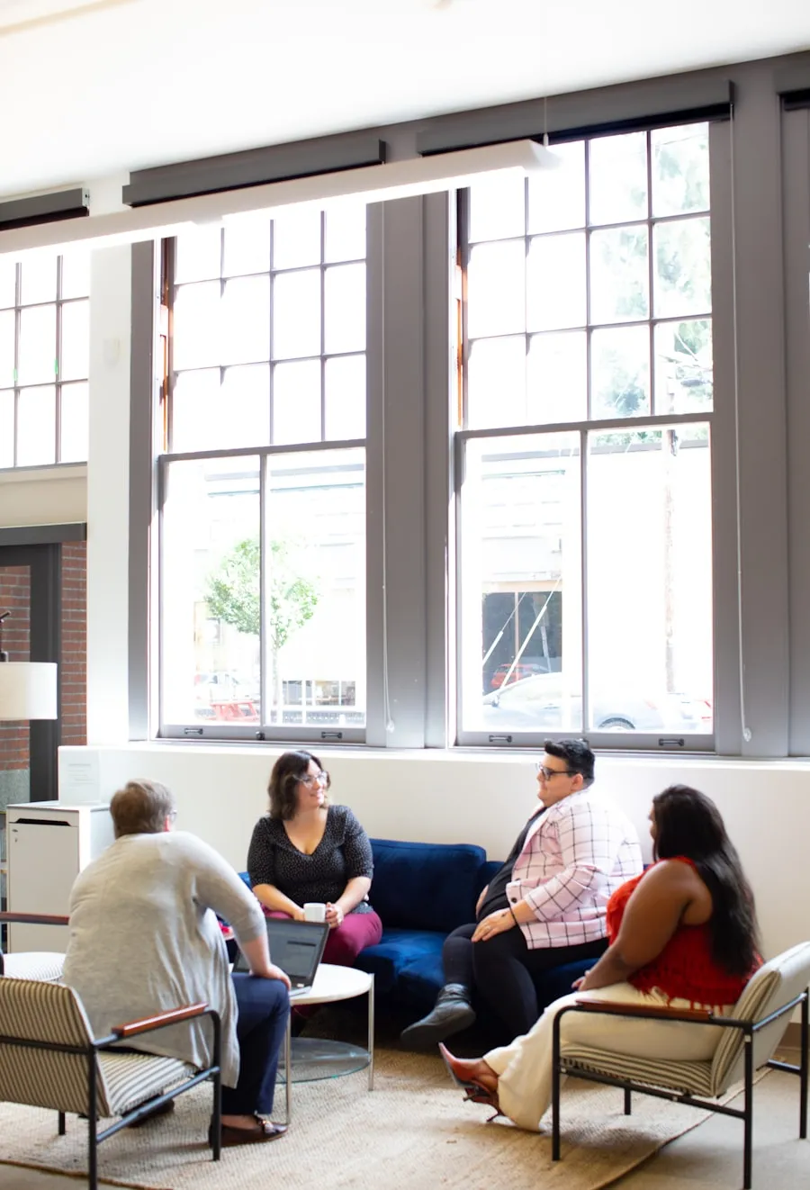 A small group of people talking together in a bright room